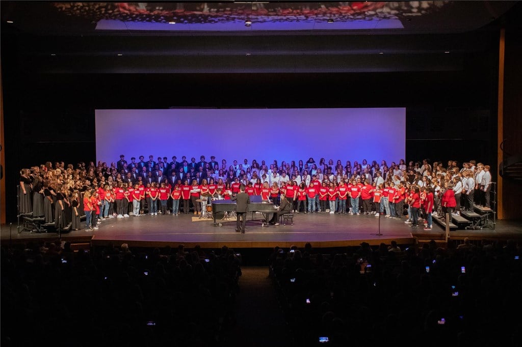 A group photo of the final performance, featuring 300+ students on stage.