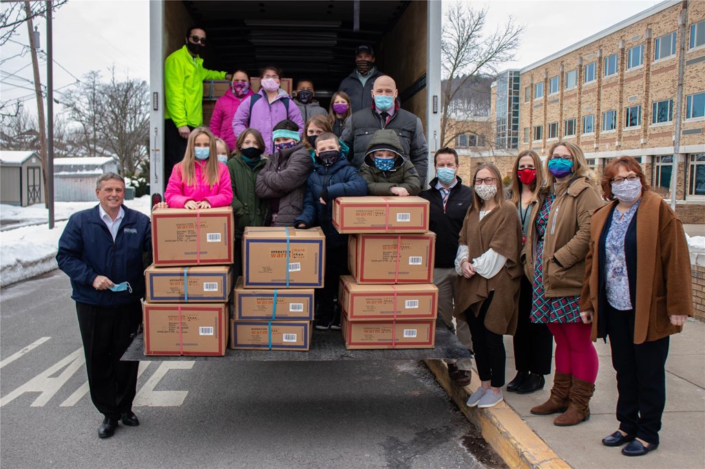Students pose as truck delivers coats.