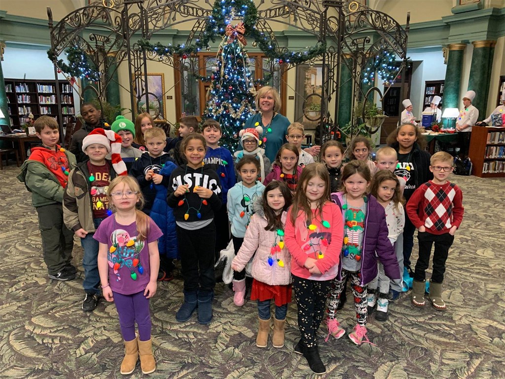 Winners from the 2019 Holiday Essay Contest pose for a photo in the Rotunda at the James V. Brown Library following that year's festivities. 