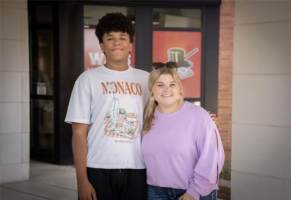A photo of the two student reps pictured outside the main entrance of WAHS.