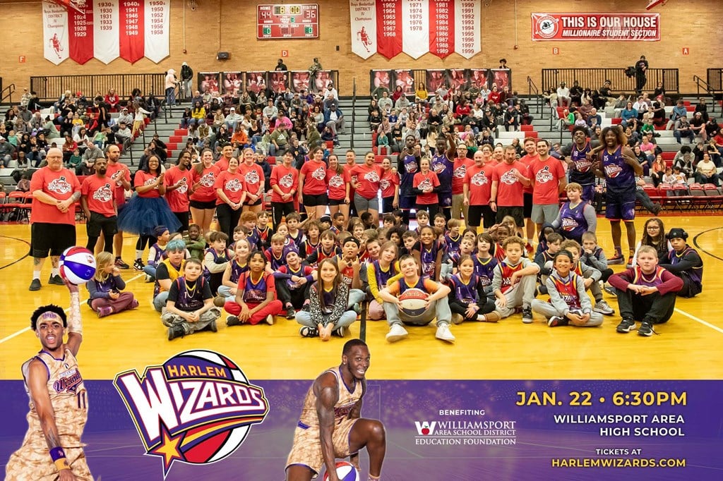 A group photo of the Millionaire Magicians with students and Harlem Wizards on the basketball court.