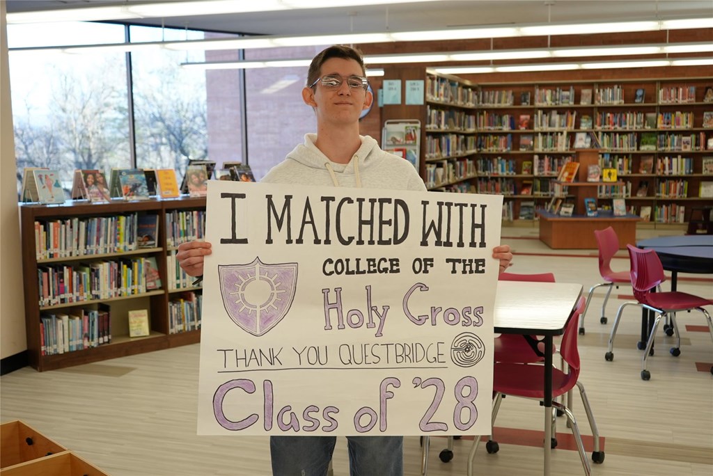 Ian stands with his poster announcing he's matched with Holy Cross.