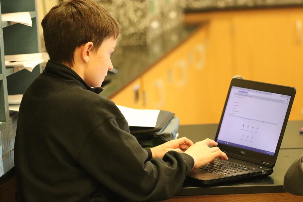Student works on laptop in science class.