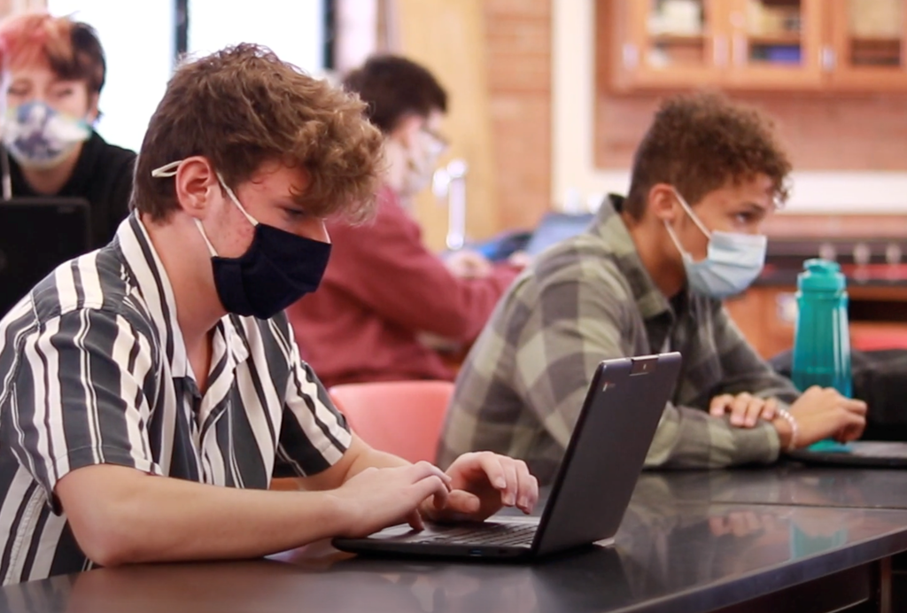 Students work on their Chromebooks with masks on.