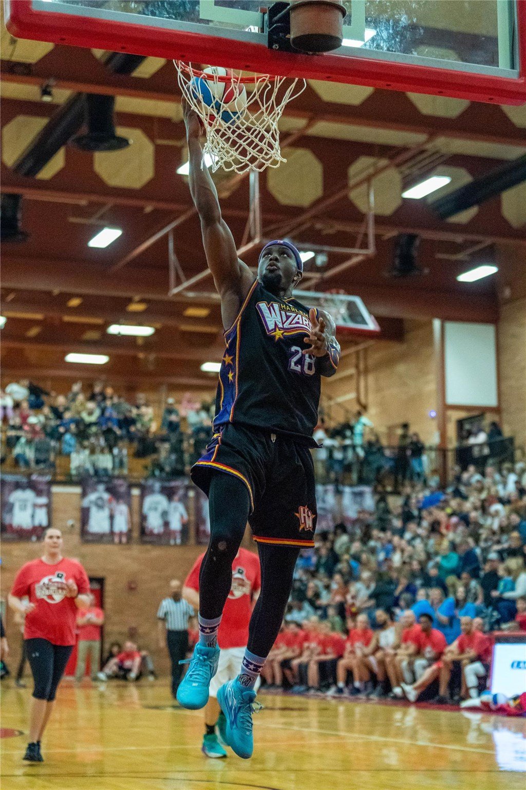 A Harlem Wizards player makes a slam dunk.